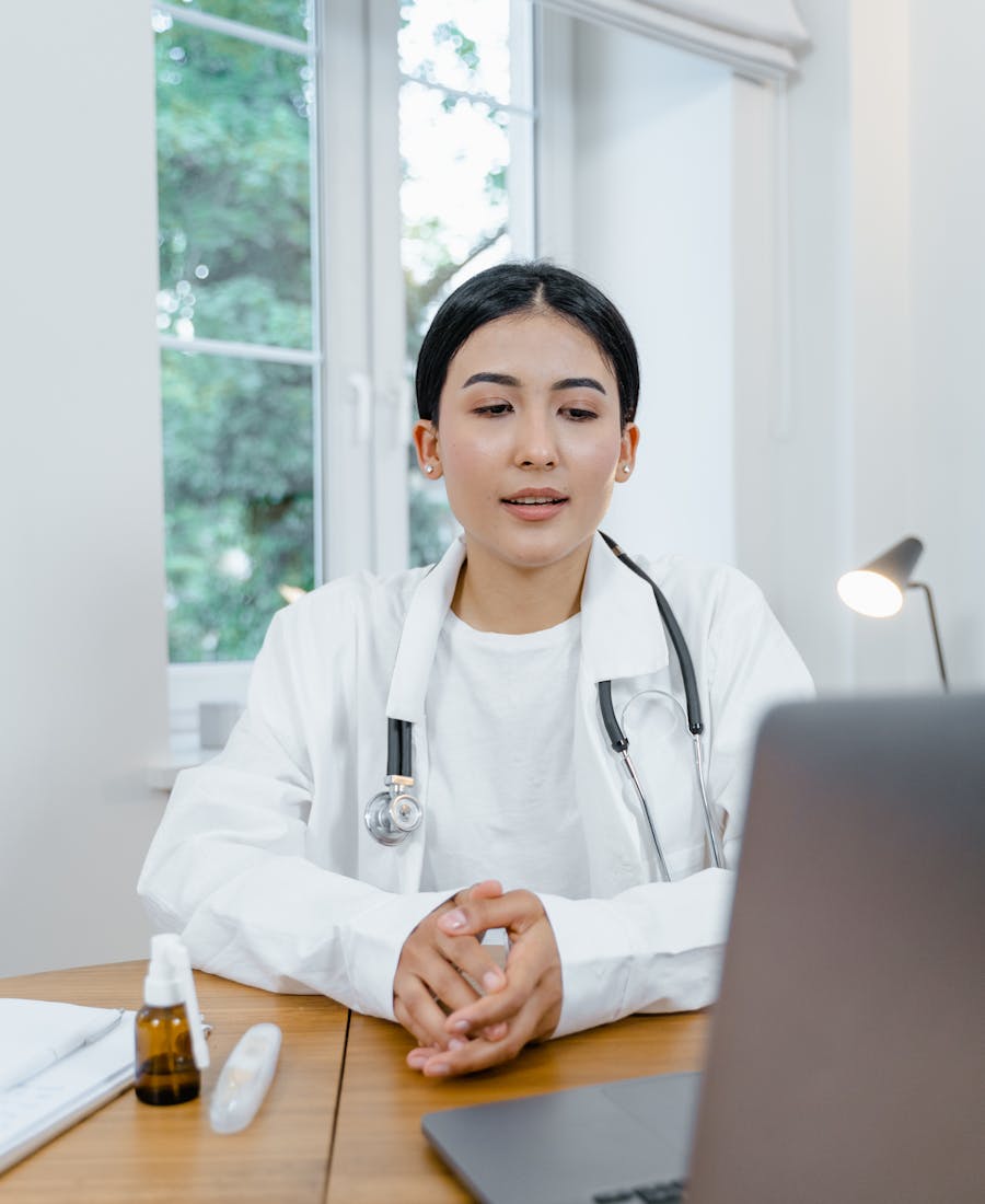 Médica em consulta online, atendendo um paciente por vídeo